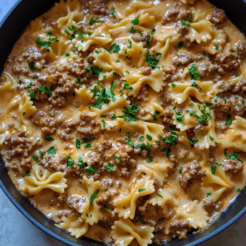 A close look at creamy pasta tossed with ground beef, farfalle, fresh parsley, and all that goodness.
